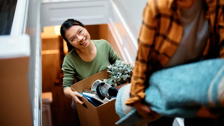 Woman carries a box upstairs
